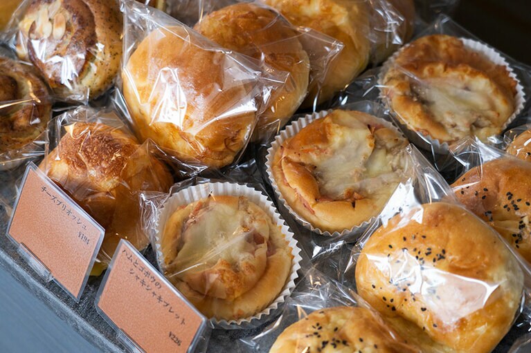 熟成生地のピザ 各324円を始め、バリエーション豊かな惣菜パンが揃う。