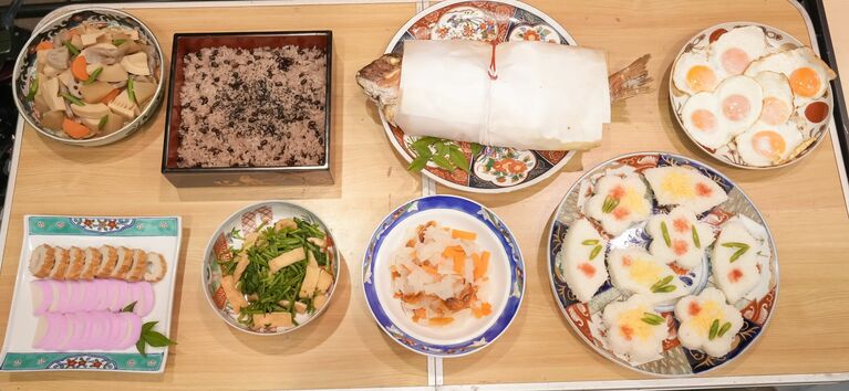 トキとヘブンの結婚パーティーの祝膳。鯛の奉書焼きをメインに、煮しめ、赤飯、あご野焼と蒲鉾、黒田せりと油揚げの煮浸し、大根と柿と人参のなます、押し寿司。松江の伝統料理に、ヘブンの大好物であるエッグスフーフーの大盛りを添えて　（C）NHK