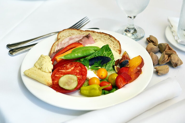 野菜たっぷりのオープンサンド。かたわらには収穫仕立てのアーモンドの実。