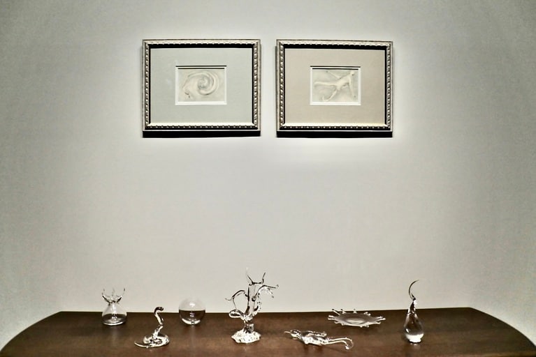 木々津鏡さんの展示。壁にはコピックや鉛筆で描いた《Glass Drawing》、テーブルにはガラスで制作した作品が並びます。