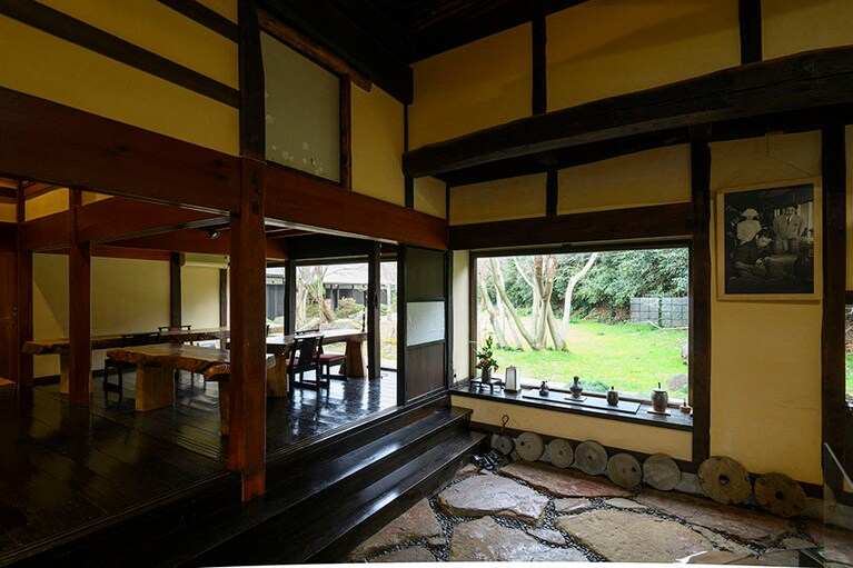 天井が高く、広々とした母家には、フロントと食事処があり、一面ガラスの窓からは中庭が。