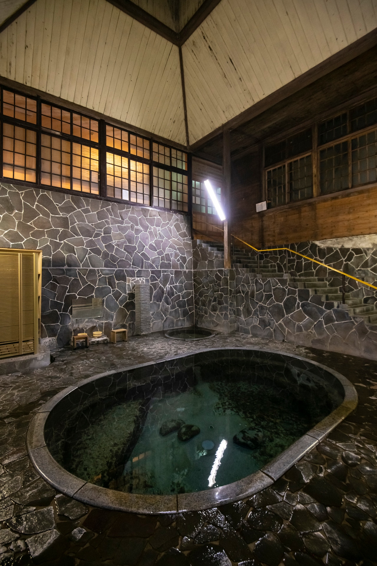 名物の立ち湯「白猿の湯」は深さ約1.25m。天然の岩を人力で掘った湯船も野趣に富む。