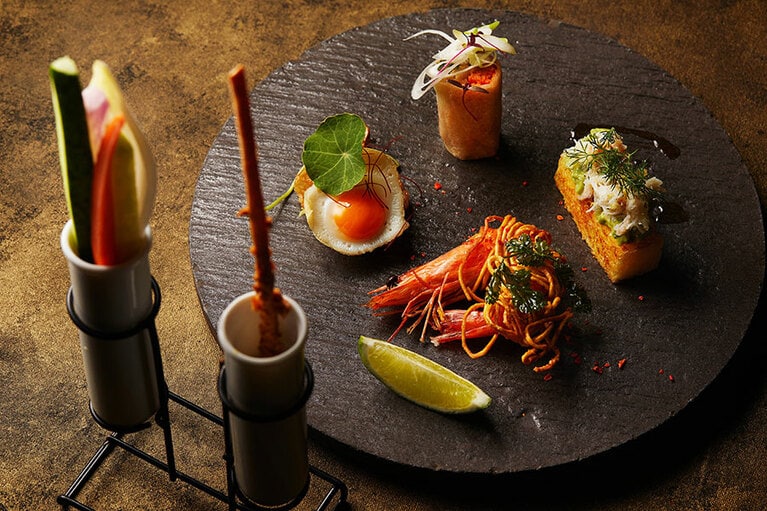 タパスセット5品 3,960円(サービス料15%別)。プレート奥は、肉厚のローストダックをカオヤーピンで巻いた北京ダック。右は蟹身がたっぷりのったブリオッシュトースト。