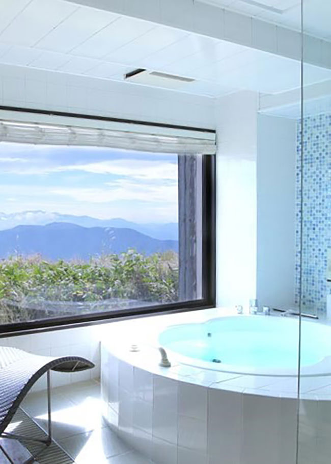 左：アルプスの山々の向こうに富士山まで望める半露天風呂。
右：展望風呂を備えたスイートルーム「あかね」。