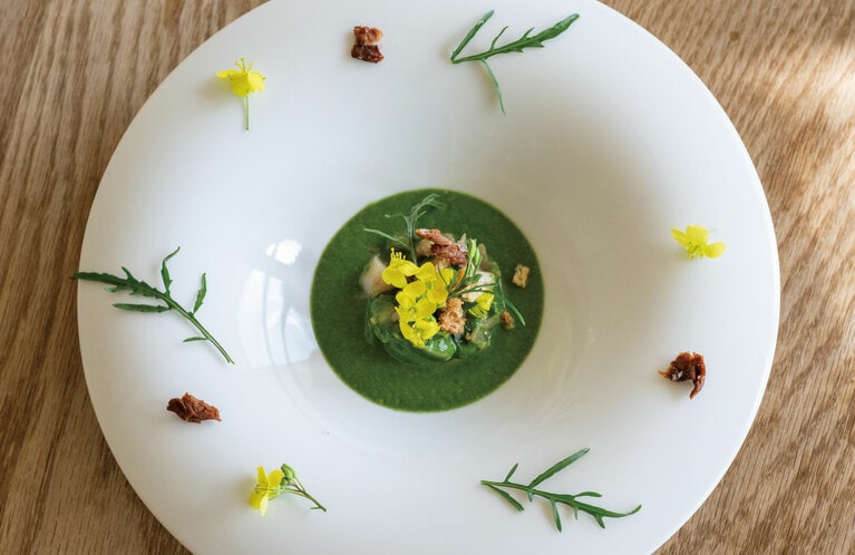 「ほうれん草のクーリーと塩麴漬けバイ貝と梅のロースト ルッコラの花を添えて」。