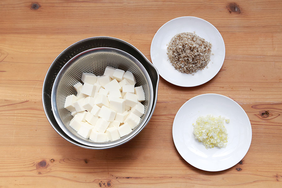 麻婆豆腐を作る。ネギ、きのこは粗みじん切り、絹ごし豆腐は茹でて賽の目に切っておく。