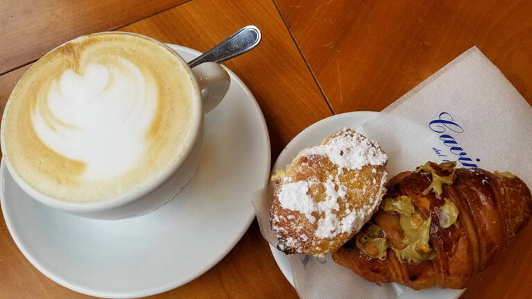 イタリアのバールの典型的な朝食。カプチーノかエスプレッソに、ピスタチオクリームやジャムが入った甘いパンを食べる。