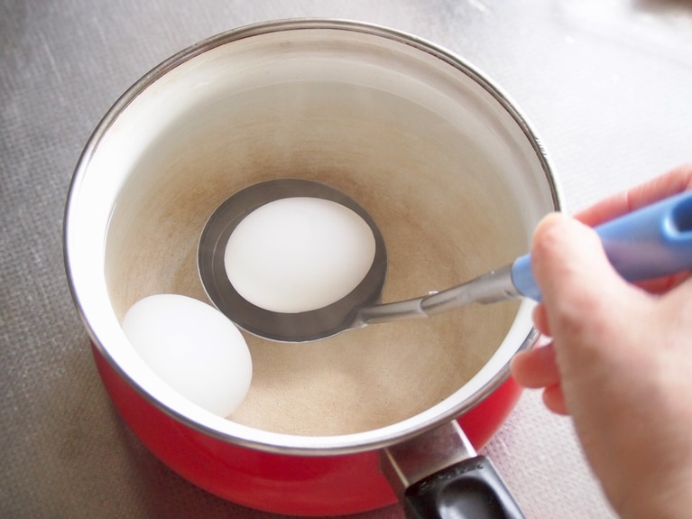 鍋に湯を沸かし、沸騰させる。おたまに乗せながら、冷蔵庫から出したての卵を、そっと入れる。