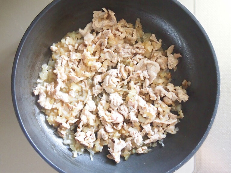 (2) フライパンに、豚肉、玉ねぎを入れて加熱し、豚肉の赤みがなくなってきたら、醤油、みりんを入れて味付けをします。汁気がなくなるまで加熱したら、一旦取り出します。