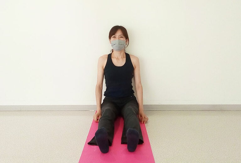ヨガマットの上に、足をまっすぐ投げ出して座る。