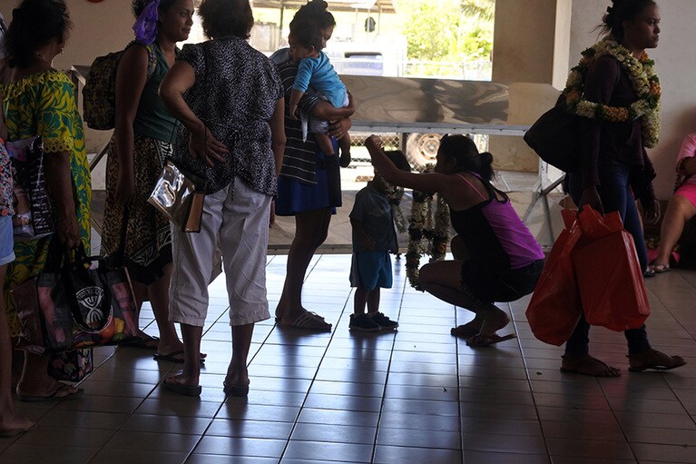 ヒバオアの空港ではレイを手に出迎える人々が。