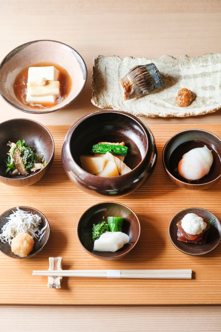 禅寺の修行僧が使う、山中塗の応量器に盛られた朝食。県内でも有数のおいしさと評判の契約農園のお米に、鯵の幽庵焼や豆腐と湯葉のあんかけなど、滋味深くも丁寧な味わい。