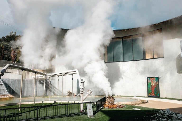 カフェに面した中庭では、この場所にもともとあった金龍地獄の源泉から湯けむりがあがる。