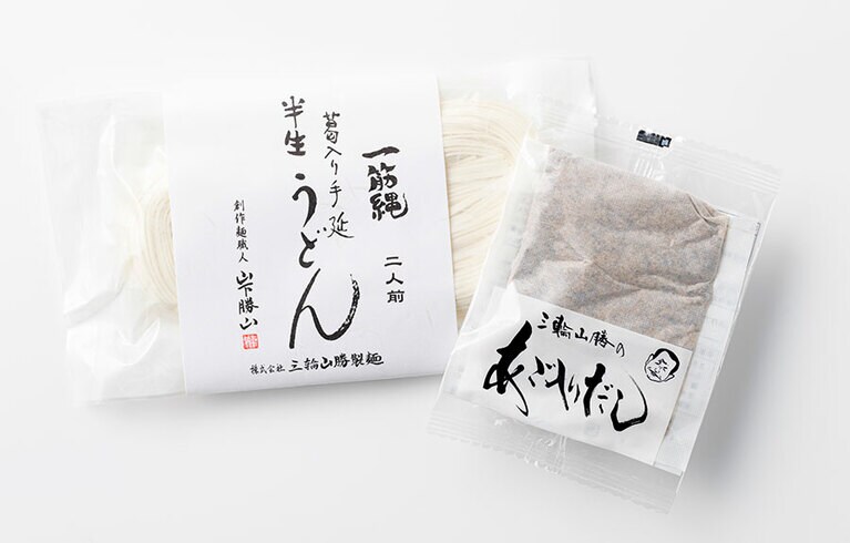 三輪山勝製麺。左から：「一筋縄生うどん(半生)」180g 540円、「あご入りだし」30g 170円(すべて税込)。