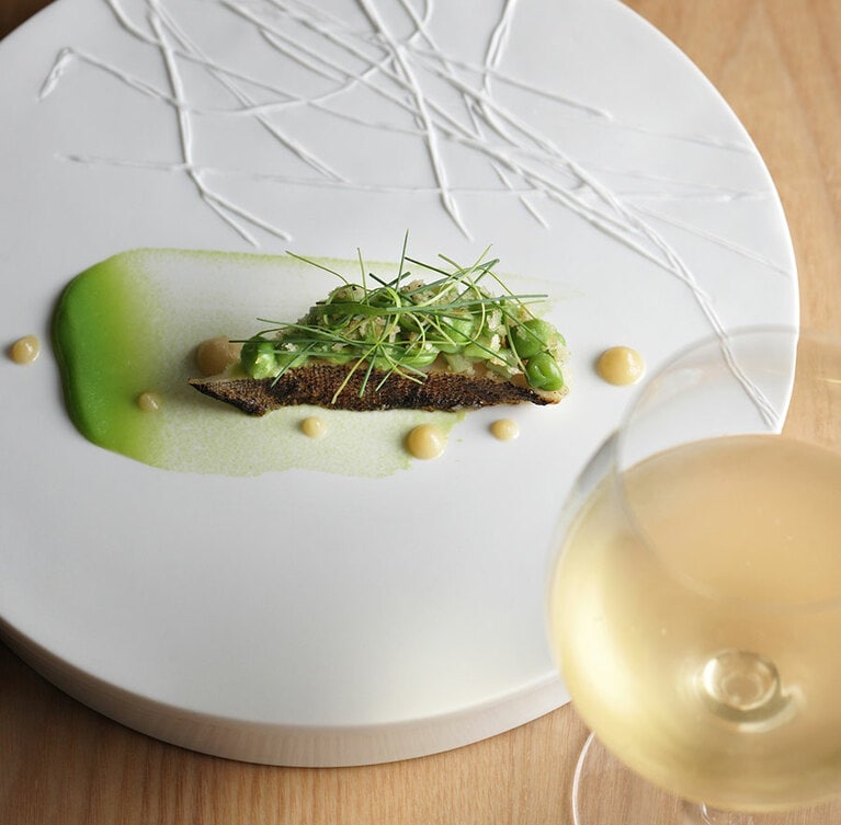 魚料理はパン粉焼きしたアイナメにマリネした東北の野菜、ミズと豆をのせた軽やかな逸品。グラスワインは1,300円～。