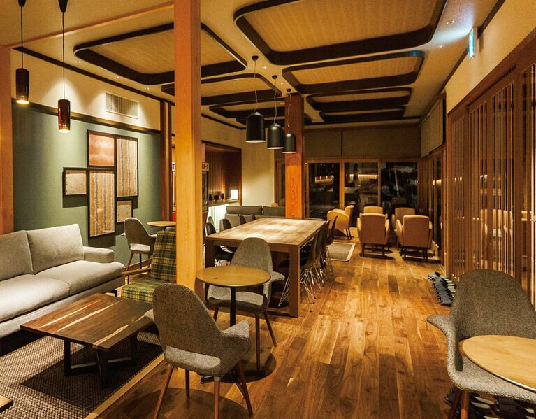 【温泉ゲストハウス 翠鳩の巣】建物のなかで最もリノベーションしたのがロビーラウンジ。木を贅沢に使い、北欧調の家具が配された温かみのあるインテリア。ここで読書をしたりモバイルで旅の情報を集めたり。奥にはライブラリーがある。