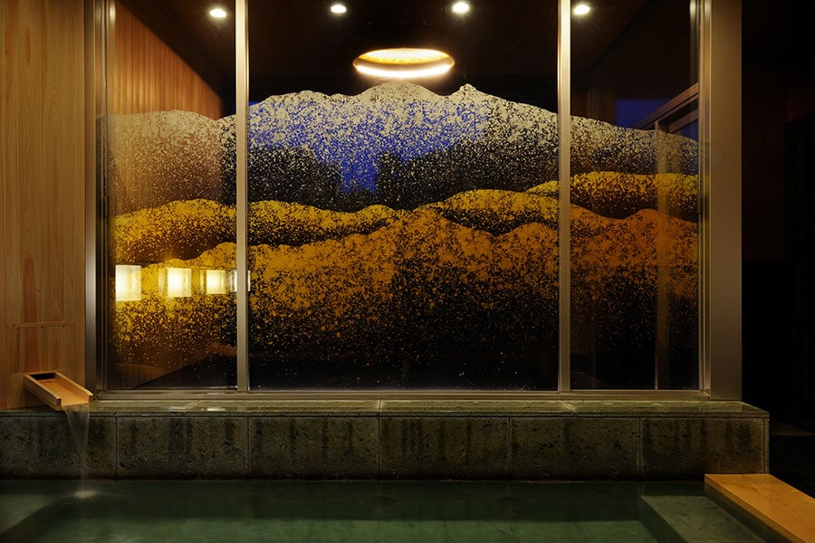 内風呂と露天風呂の仕切りガラスには、金箔で霊峰白山が描かれている。