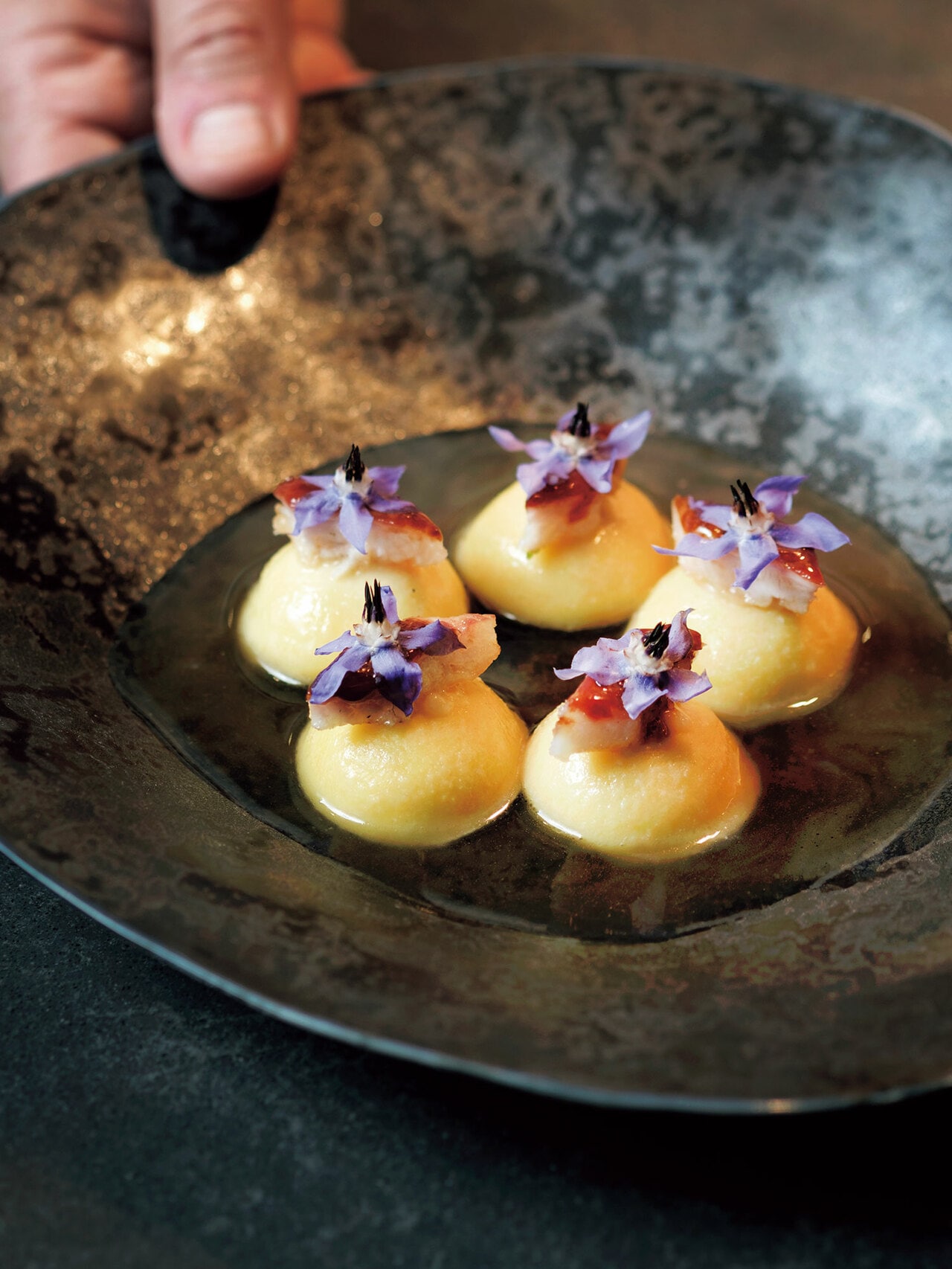 ロースト度合いが異なるピーナッツを餡にして詰めたラビオリにスモークした鰻、柑橘と鶏のブロスを注ぐ。ピーナッツの芳醇な甘みに鰻のとろける脂と香ばしさが調和する（50ユーロ）。コースは一人前220ユーロのおまかせのみ。アラカルトも注文可。白トリュフの時期には特別コースも。