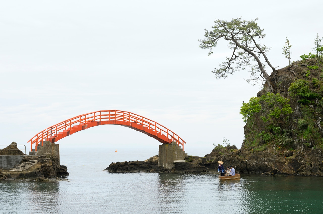 矢島体験交流館では、朱塗りの太鼓橋が美しい矢島・経島の風光明媚な入江の景色が楽しめます。予約をすれば磯釣りやイカの一夜干し体験も。