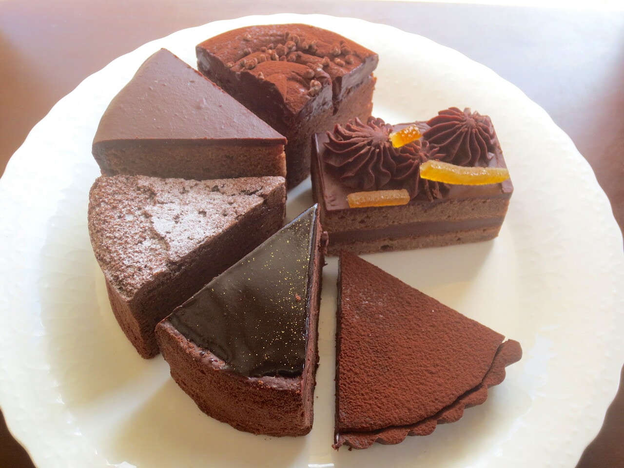 チョコレート菓子6種。左上より時計回りに「ザッハトルテ」550円、「モワールショコラガナッシュ」580円、「ケイクガナッシュ」420円、「生チョコタルト」550円、「グランショコラ」580円、「ガトーショコラ」420円。