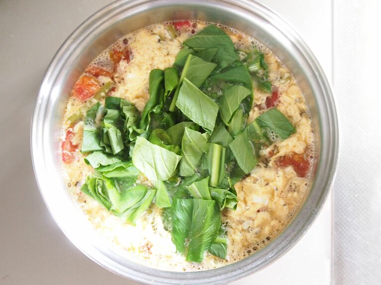 卵に火が入ったら、小松菜の葉の部分を入れる。