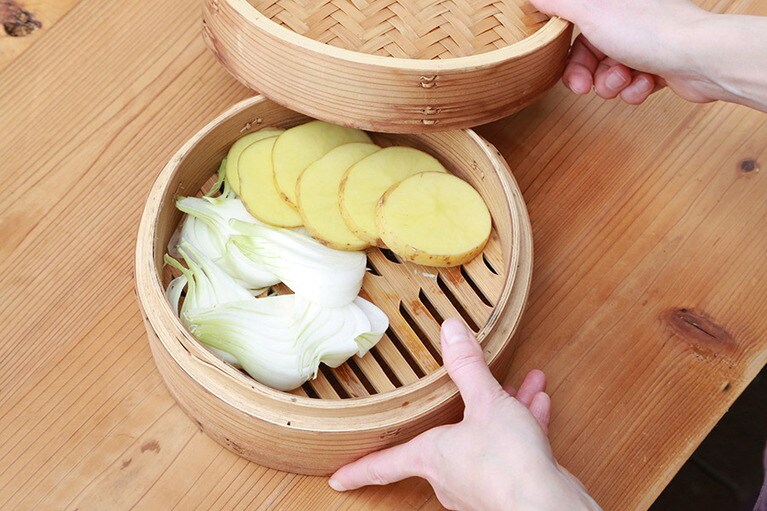 せいろに新玉ねぎと新じゃがを入れて10分程度蒸し、途中から春キャベツを加えてさらに3、4分蒸す。春キャベツは柔らかく火の通が早いので後から加える。加熱しすぎないことできれいな色に仕上げることができる。中華風ピリ辛ゴマソースを添えてせいろごと食卓へ。