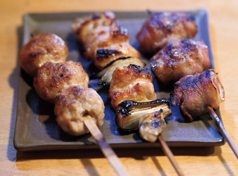 左からつくね、正肉（ねぎま）、とまと巻各300円。提供する皿は同じく相川に工房を置く北沢窯の無名異焼。佐渡ならではの焼物。