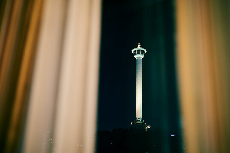 南浦洞にあるホテルの部屋から見える釜山のランドマーク「釜山タワー」は、市の中央に位置する龍頭山公園の中にある。1973年に建設されたタワーの展望台にはカフェがあり、タワーの地上部にはみやげ物店やギャラリーも。