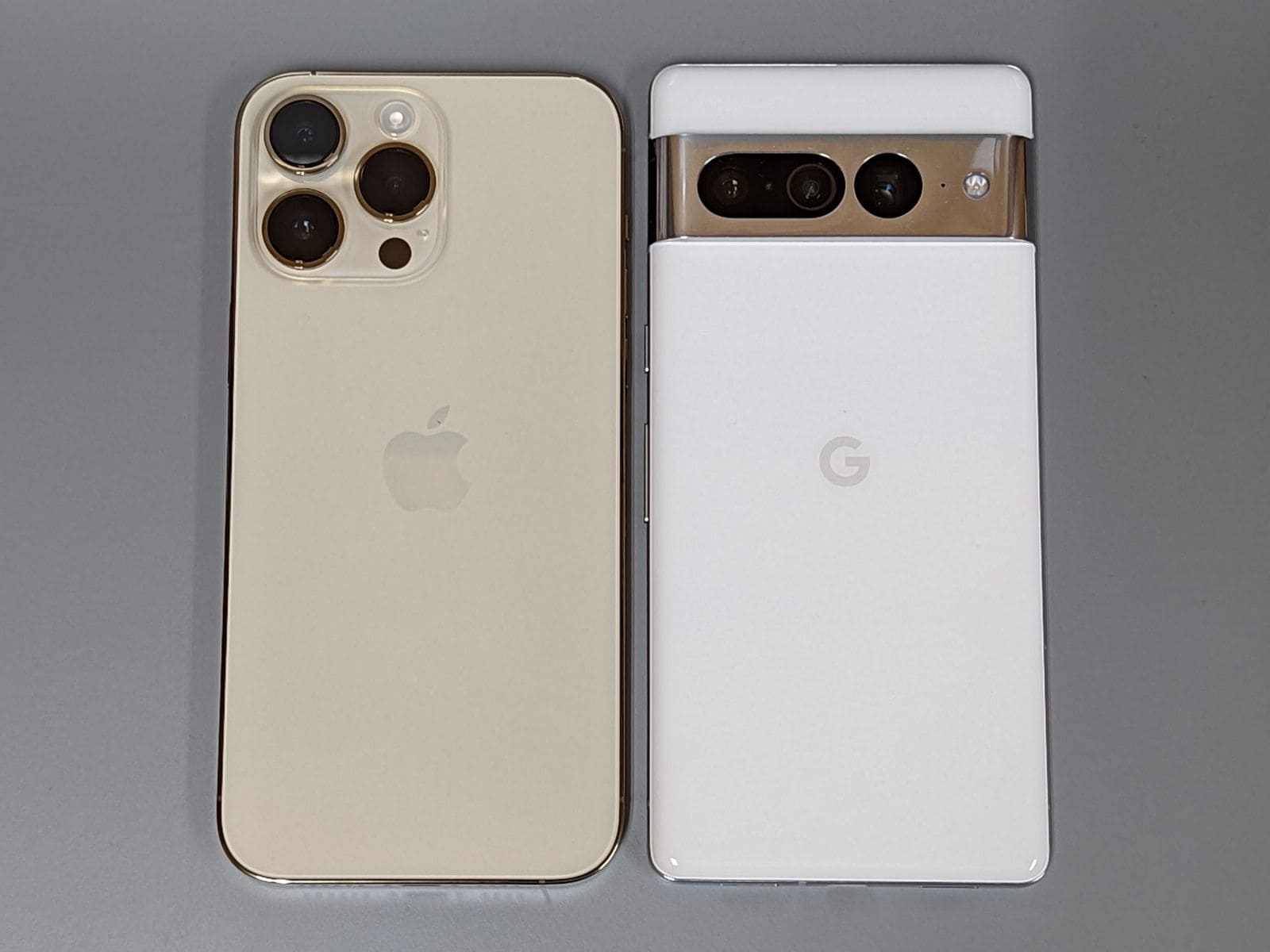 こちらは背面。iPhone（左）はカメラ部が左側にまとまっているため、平らなところに置くとガタつきます