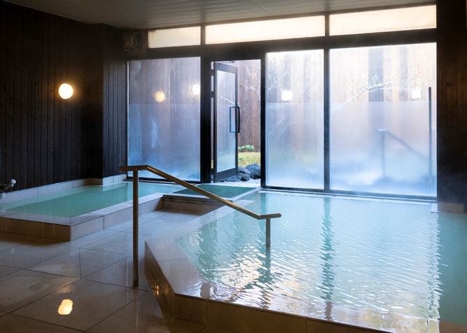 大浴場も源泉掛け流し。旅館からほど近い「湯の平湿原」の硫黄泉を引湯している。