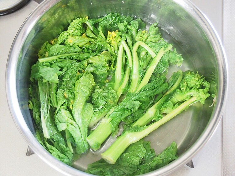 (2) 20〜30秒ほどたったら、葉の部分を入れてサッと茹でます。 すぐに冷水に取り出し、冷やします。水気をよく絞ったら、みじん切りにします。