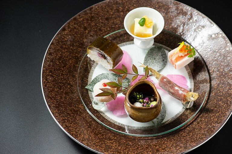 冬の奥嵐山を思わせる八寸「雪待月の肴核(こうかく)」。裏ごしした百合根で白あんを包んだ「百合根玉雪」はタンチョウヅルを、周りにまぶした氷餅は雪が陽の光に反射する情景を表現。