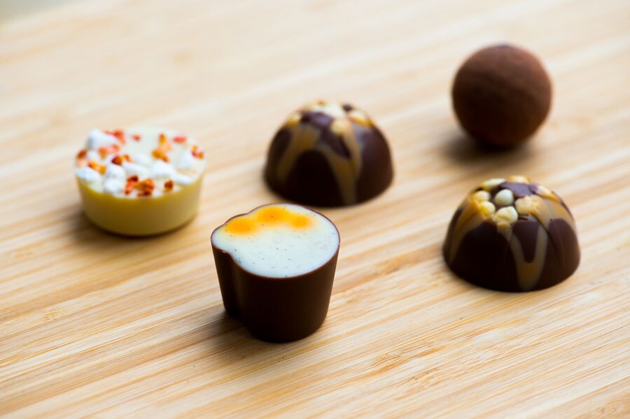 ボール状のチョコレートムース、ドーム形のビリオネアズ ショートブレッド、白とオレンジ色のキャロットケーキ、白いイートン メス。