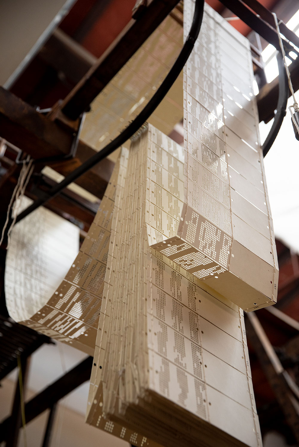 1786年創業当時から使われている機織り機は各機がフィレンツェ名家専用。頭上の台紙に紋章のデザインが刻まれている。