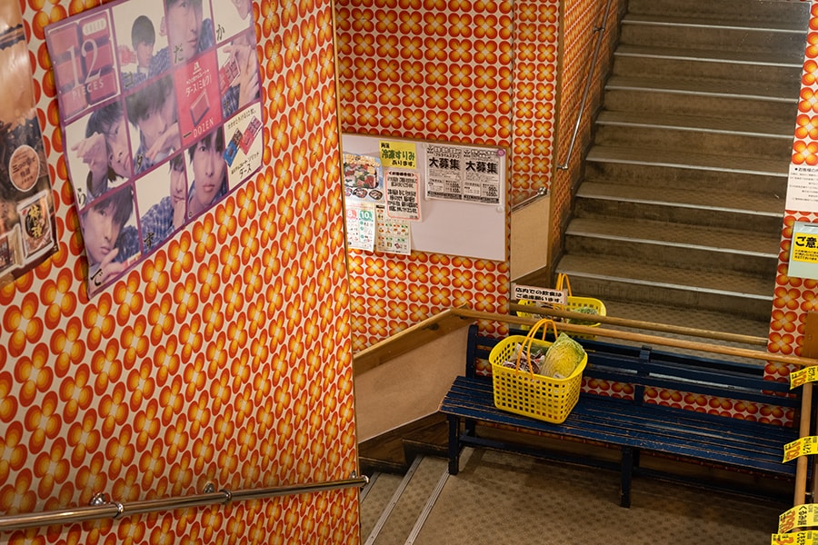 階段には荷物を置いたり休憩ができるベンチも。懐かしのポスターが貼られている壁も必見。