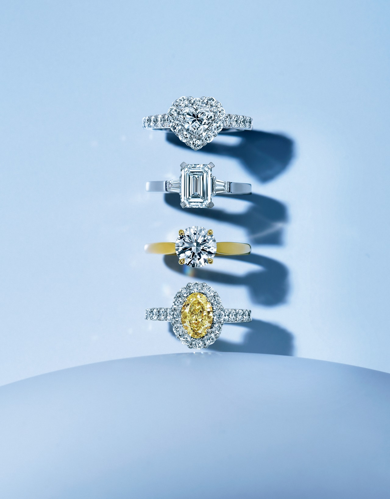 ≪上から≫パヴェダイヤモンドがセンターストーンを取り囲み、華麗な輝きを際立たせる「アイコン」。ハートシェイプのダイヤモンドを光の輪が包み込む。リング「アイコン」（WG×ダイヤモンド （センター0.7ct、周囲トータル1.4ct））1,510,000円（センター0.5ct～、1,100,000円～）　ソリテールダイヤモンドを優美な輝きのショルダーストーンが飾る「プロミス」。エメラルドカットのダイヤモンドがクラシカルで知的な印象を醸す。リング「プロミス」（PT×ダイヤモンド （センター1.51ct、サイドトータル0.29ct））4,220,000円（センター0.5ct～、1,000,000円～）　ダイヤモンドの唯一無二の輝きを最も美しく引き出す「パラゴン」。スレンダーなバンドにラウンドブリリアントカットのダイヤモンドが華やかな光を放つ。リング「パラゴン」（YG×ダイヤモンド（1.5ct））6,100,000円（0.5ct～、650,000円～）　オーバルシェイプのイエローダイヤモンドをホワイトダイヤモンドのラインが囲む「アイコン」は、眩いばかりのボリューム感。リング「アイコン」（WG×YG×イエローダイヤモンド （1.28ct）×ホワイトダイヤモンド （周囲トータル1.33ct））4,435,000円（センター1ct～、4,000,000円～）／グラフ（グラフダイヤモンズジャパン）