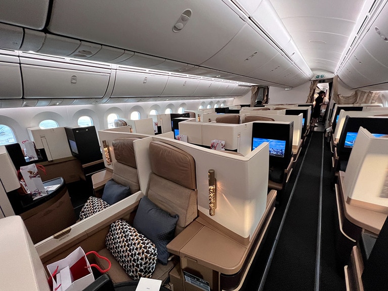 ビジネスクラスのシートは、進行方向に向かって前方向きと後方向きが交互に配置されている。写真手前は前方向き、その奥に見えるモニターは後方向きのシートのものだ。