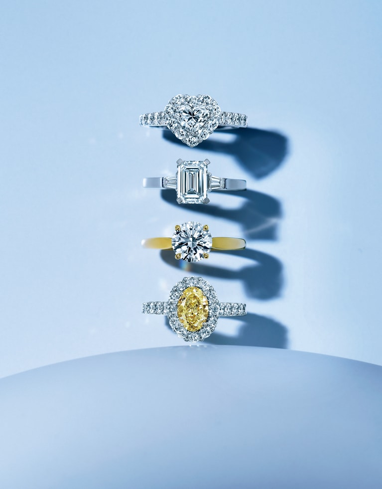 ≪上から≫パヴェダイヤモンドがセンターストーンを取り囲み、華麗な輝きを際立たせる「アイコン」。ハートシェイプのダイヤモンドを光の輪が包み込む。リング「アイコン」（WG×ダイヤモンド （センター0.7ct、周囲トータル1.4ct））1,510,000円（センター0.5ct～、1,100,000円～）　ソリテールダイヤモンドを優美な輝きのショルダーストーンが飾る「プロミス」。エメラルドカットのダイヤモンドがクラシカルで知的な印象を醸す。リング「プロミス」（PT×ダイヤモンド （センター1.51ct、サイドトータル0.29ct））4,220,000円（センター0.5ct～、1,000,000円～）　ダイヤモンドの唯一無二の輝きを最も美しく引き出す「パラゴン」。スレンダーなバンドにラウンドブリリアントカットのダイヤモンドが華やかな光を放つ。リング「パラゴン」（YG×ダイヤモンド（1.5ct））6,100,000円（0.5ct～、650,000円～）　オーバルシェイプのイエローダイヤモンドをホワイトダイヤモンドのラインが囲む「アイコン」は、眩いばかりのボリューム感。リング「アイコン」（WG×YG×イエローダイヤモンド （1.28ct）×ホワイトダイヤモンド （周囲トータル1.33ct））4,435,000円（センター1ct～、4,000,000円～）／グラフ（グラフダイヤモンズジャパン）