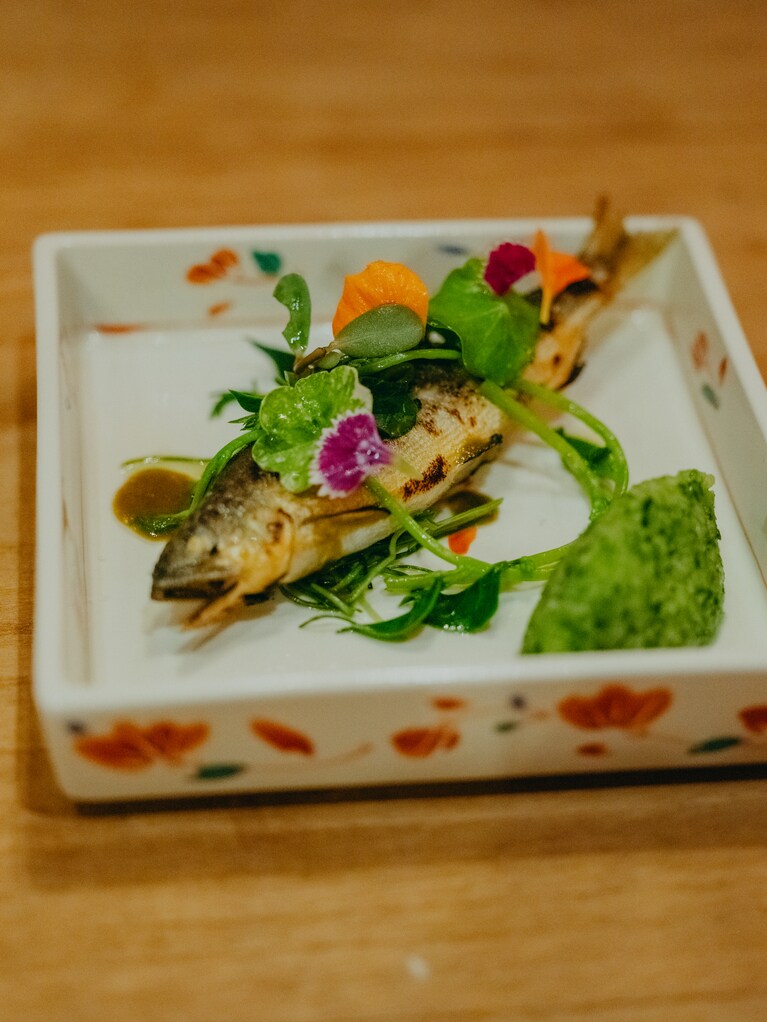 山菜やハーブを合わせた鮎のコンフィ。山をイメージした緑のソースは新潟県魚沼地方の郷土料理“きりざい”。「きりざいは以前、ごはんに合わせて食べたことがあったのだけど、印象が変わりました。瑞々しくてすごく美味しい！ 」（星野さん）その土地の郷土料理の美味しさに気づくというのも、素晴らしい旅の体験のひとつ。