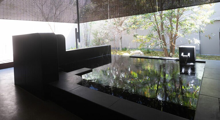 宿房の露天風呂付きのバスルーム。温泉かけ流し露天風呂と、スパトリートメントを堪能できる専用スペースを全室に備えている。