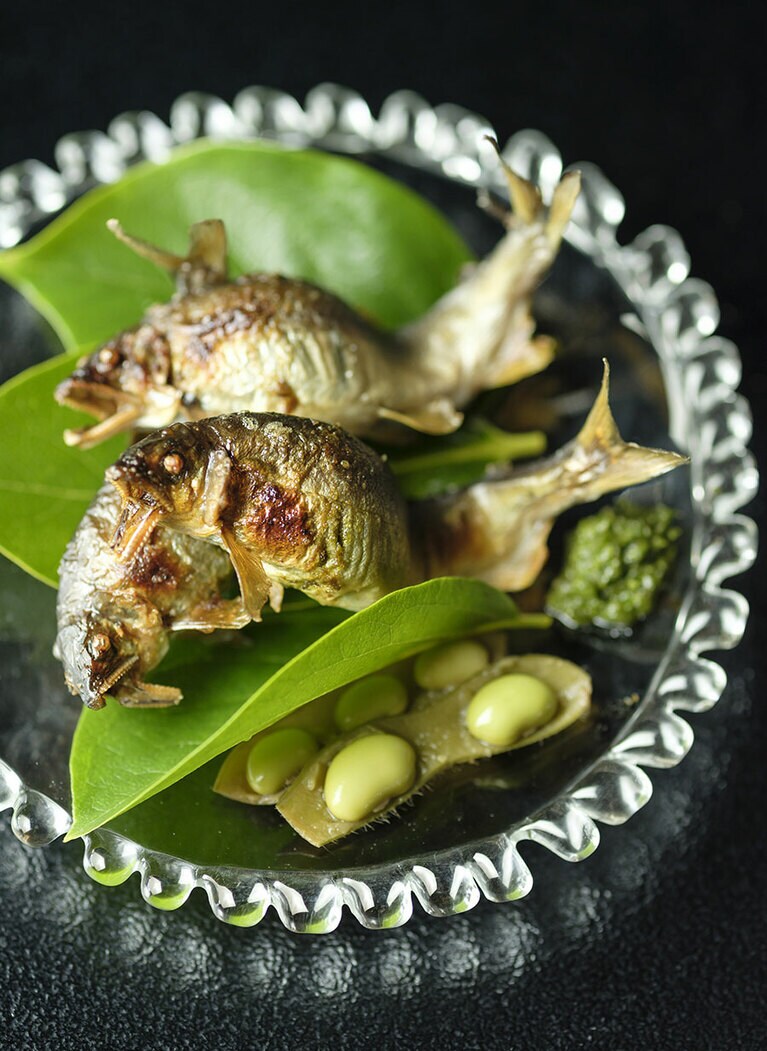 頭から一気に食べたい鮎の塩焼き。コシアブラのペースト添え。鮎は外の焼き台でひたすら焼く。