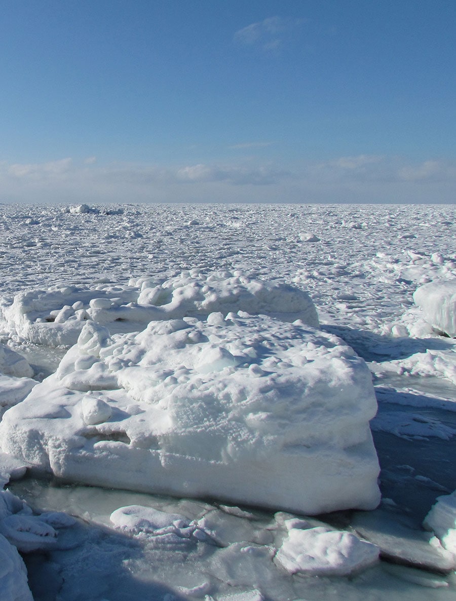 写真左：例年1月下旬ごろ知床半島に接岸する流氷。
写真右：温もりある空間に癒やされる「オホーツク倶楽部・露天風呂付きスイート」。