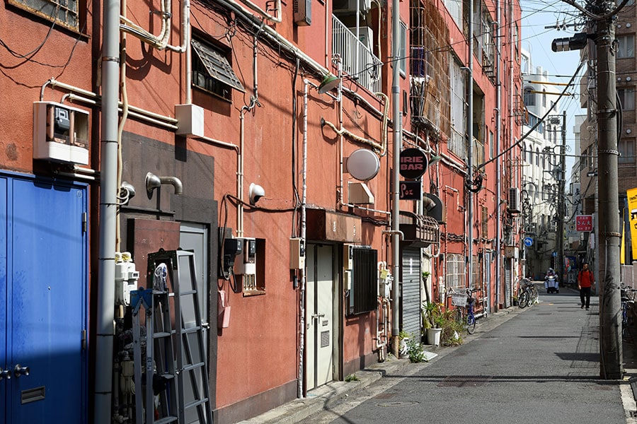 吉田町第一名店ビルの裏側は、一面赤色の壁が続き、むき出しの配管やケーブルが何ともフォトジェニック。