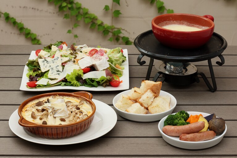 「きのこ焼きチーズドリア カマンベール」 1,700円、「自家製チーズの贅沢サラダ 」2,300円。