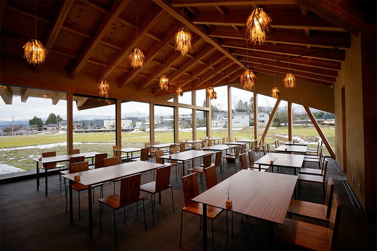 ランチのみ営業している「ザ・キッチン」からは、ガラス越しに田園風景を望むことができる。イスやテーブルはすべて富山産の杉で作られている。