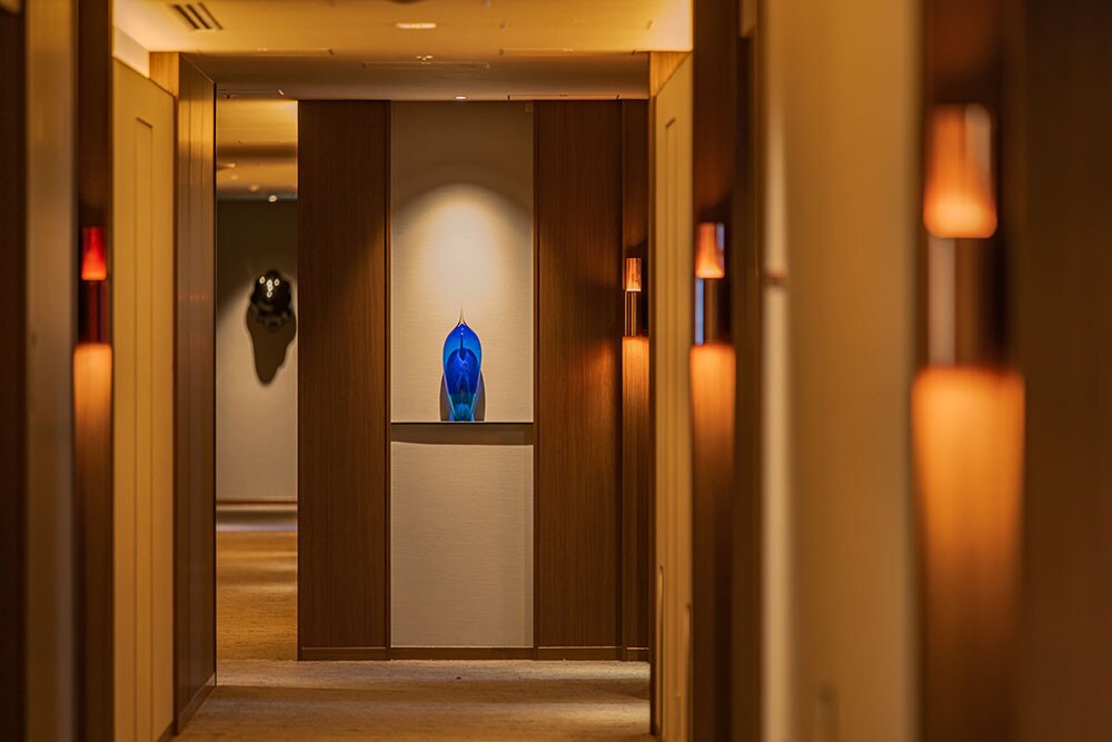 廊下を彩る意匠は、「開化堂」の茶筒の製法を用いたルームサイン、石塚源太氏の漆アート、佐藤聡氏のガラスアートなど。