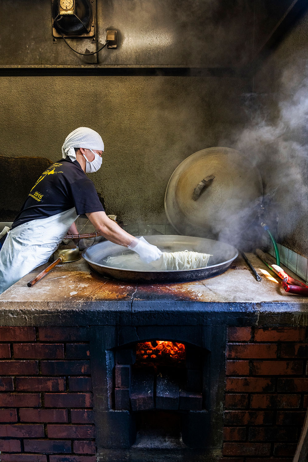 薪を燃やし大鍋で麵を茹でる。窯から出る煙が麵をスモークし、独特の風味が完成。