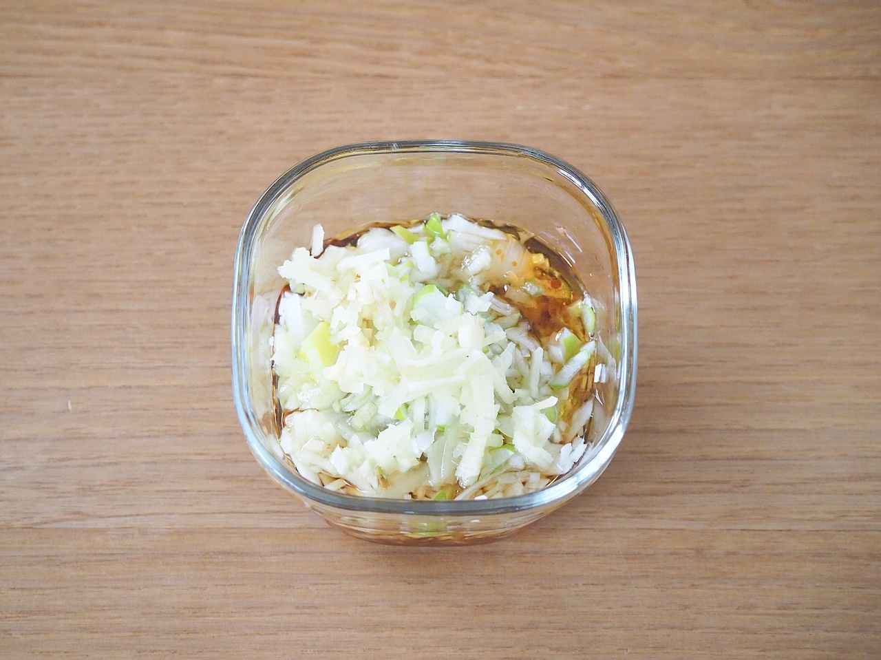 長ネギ、生姜をみじん切りにする。容器に入れ、＜タレ調味料＞を混ぜ入れて味をなじませる。