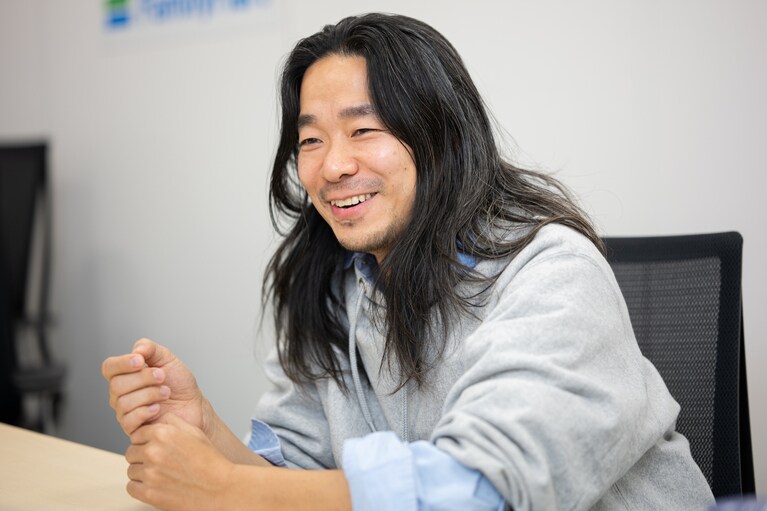 落合宏理さん。取材当日に本人が着用しているグレーのパーカーも、もちろんコンビニエンスウェアのもの。