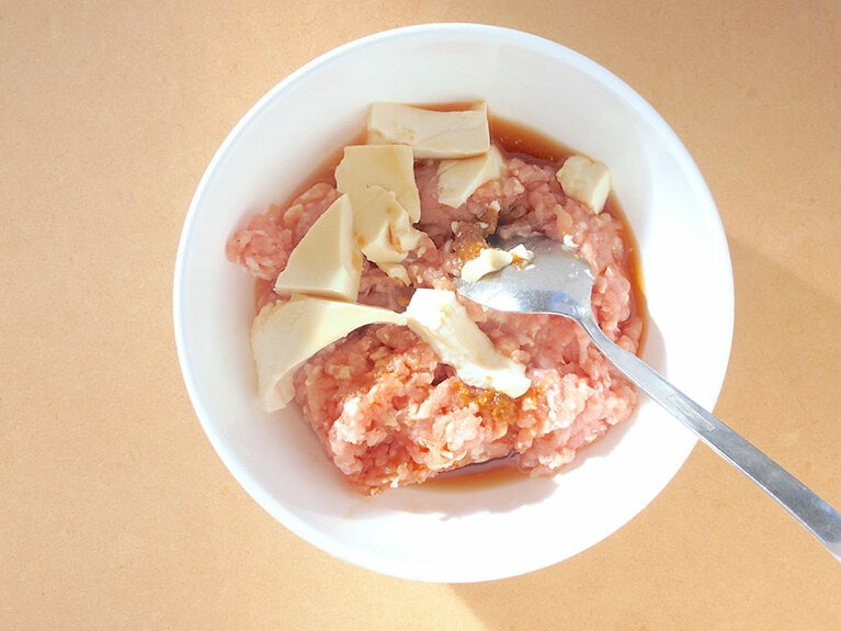(2) ボウルに鶏もも挽き肉、豆腐、Aの調味料を入れてよく混ぜます。 豆腐が鶏肉としっかり馴染むまで混ぜるようにしましょう。